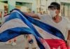Manifestante levanta una bandera ensangrentada, el pasado 11 de julio durante la revuelta popular en Cuba. (Foto original: AFP)