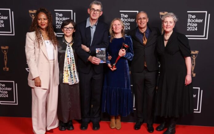 Samantha Harvey (centro) con su Booker Prize 2024, junto a los jurados Collins, Yiyun Li, Edmund de Waal, Nitin Sawhney y Justine Jordan