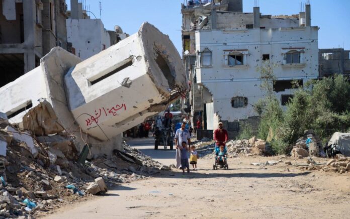 Una familia palestina camina junto a una mezquita destruida en Gaza