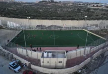 Siete escritores, ilustradores y promotores de lectura palestinos, nominados al Premio Astrid Lindgren 2027 Cancha de fútbol junto al muro de separación israelí en el campo de refugiados de Aida, en Belén, donde opera el Lajee Center, nominado al Premio Astrid Lindgren 2027.