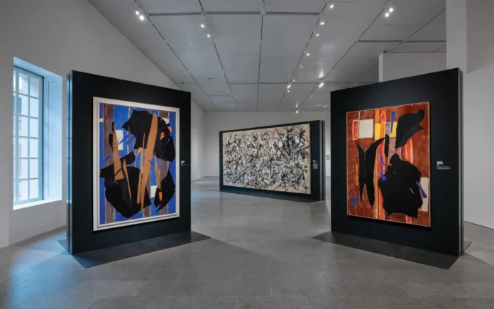 Sala de la exposición ‘Krasner and Pollock: Past Continuous’ con tres grandes pinturas abstractas sobre paneles negros en el Met.