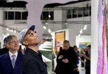 Art Basel seguirá en Miami Beach hasta 2031 tras amenazas de mudarse a Las Vegas Visitantes observan pinturas y una gran silueta blanca de brazos abiertos en una sala de Art Basel Miami Beach.